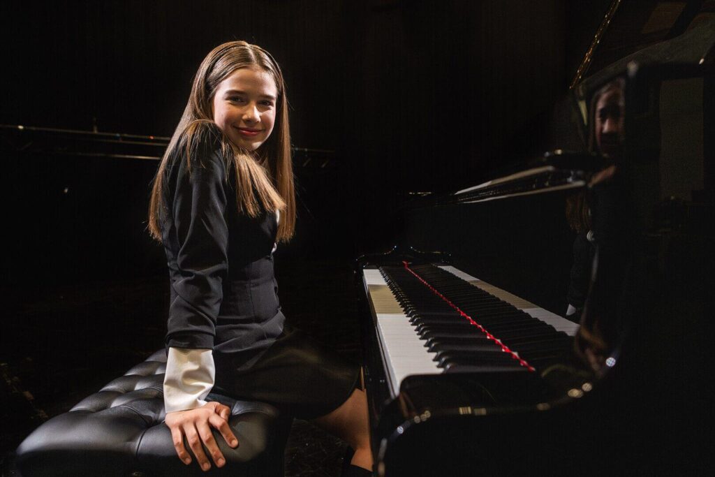 Arhanna is sittnig at the piano. She represent Estonia in the JESC 2023.